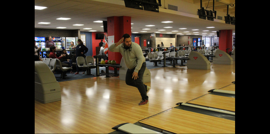 Hispanic male releases bowling ball.